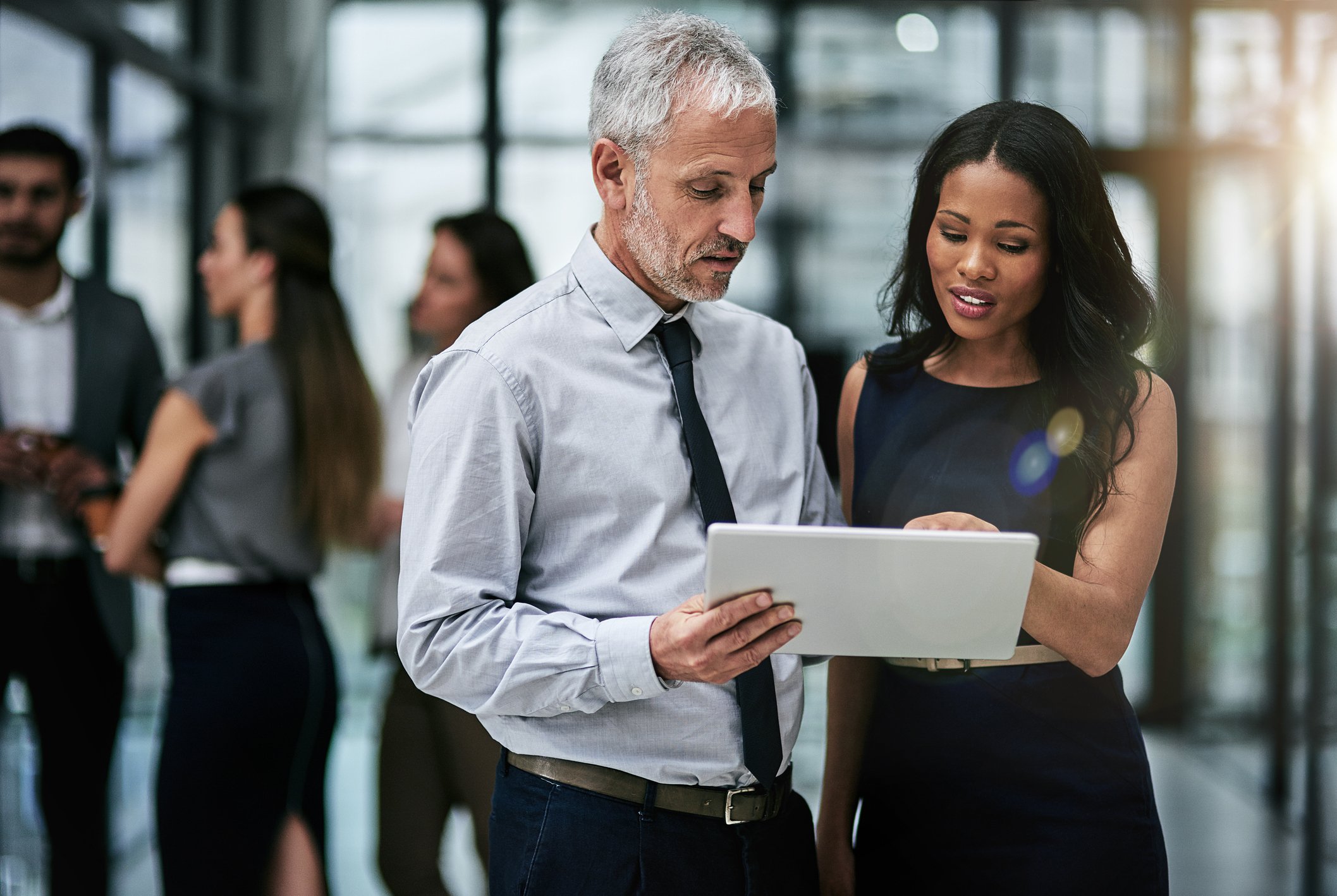 Businesspeople looking at a tablet.