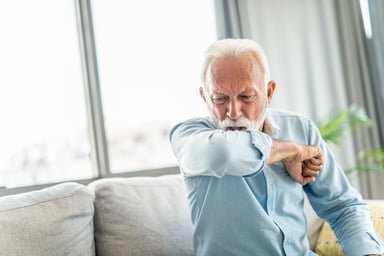 Person coughing into elbow_GettyImages-1273570925