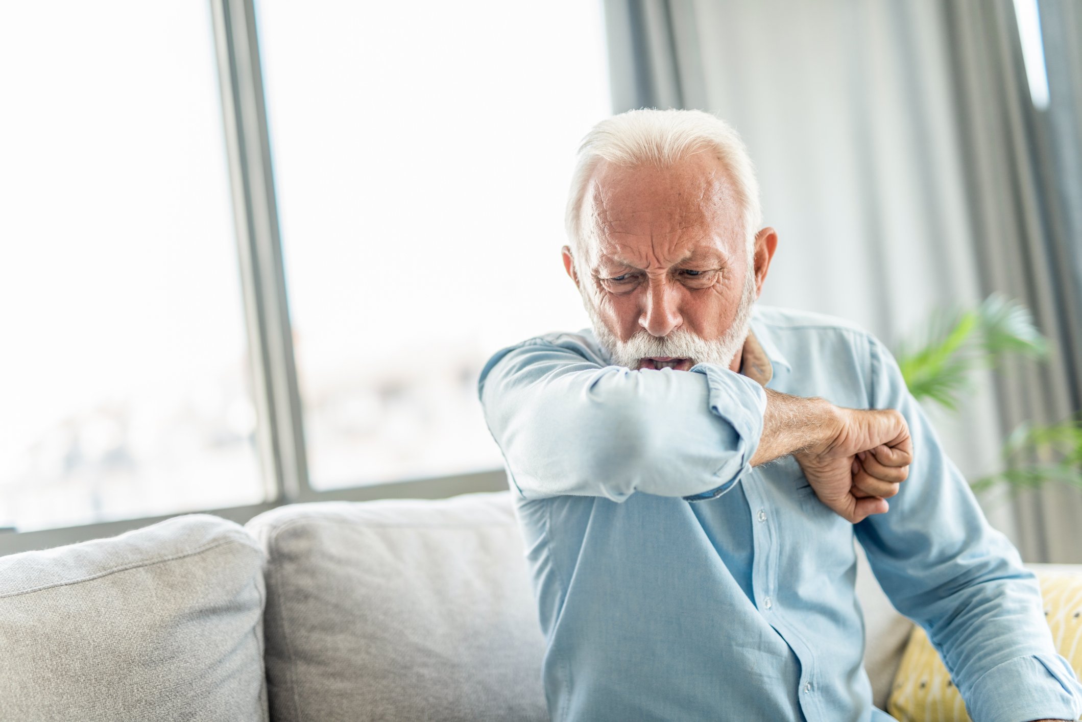 Person coughing into elbow.
