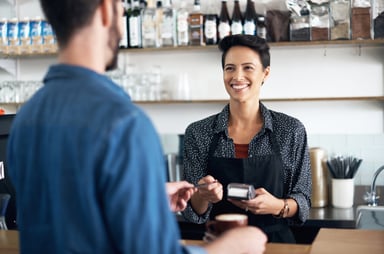 A barrista accepting a card payment at a cafe