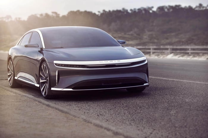 Navy blue Lucid Air sedan on road.