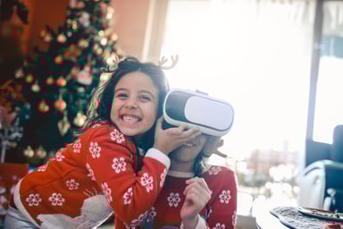 Two children, one wearing a VR headset.