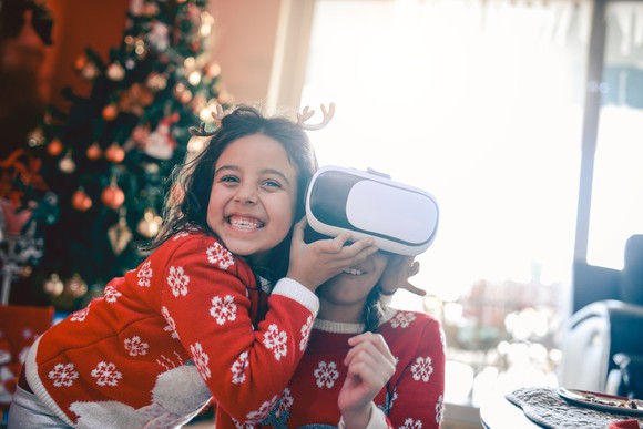 Two children, one wearing a VR headset.