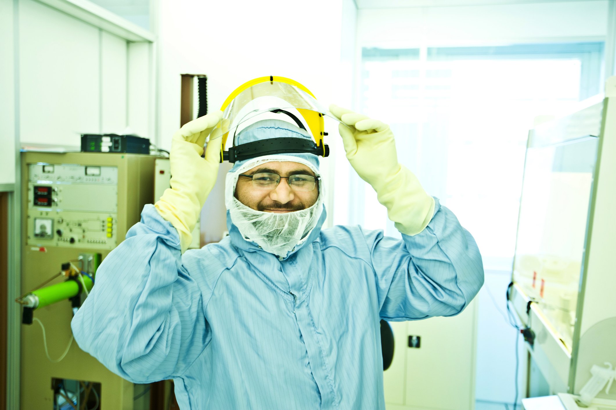 A semiconductor foundry employee prepares to lower their face shield.