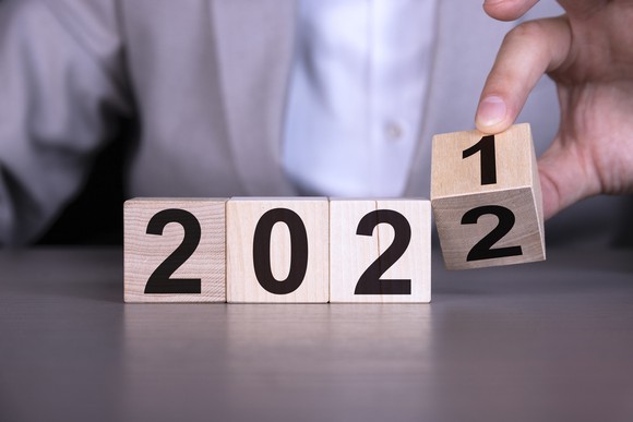 A person flipping wooden cube block to change 2021 year to 2022 year.