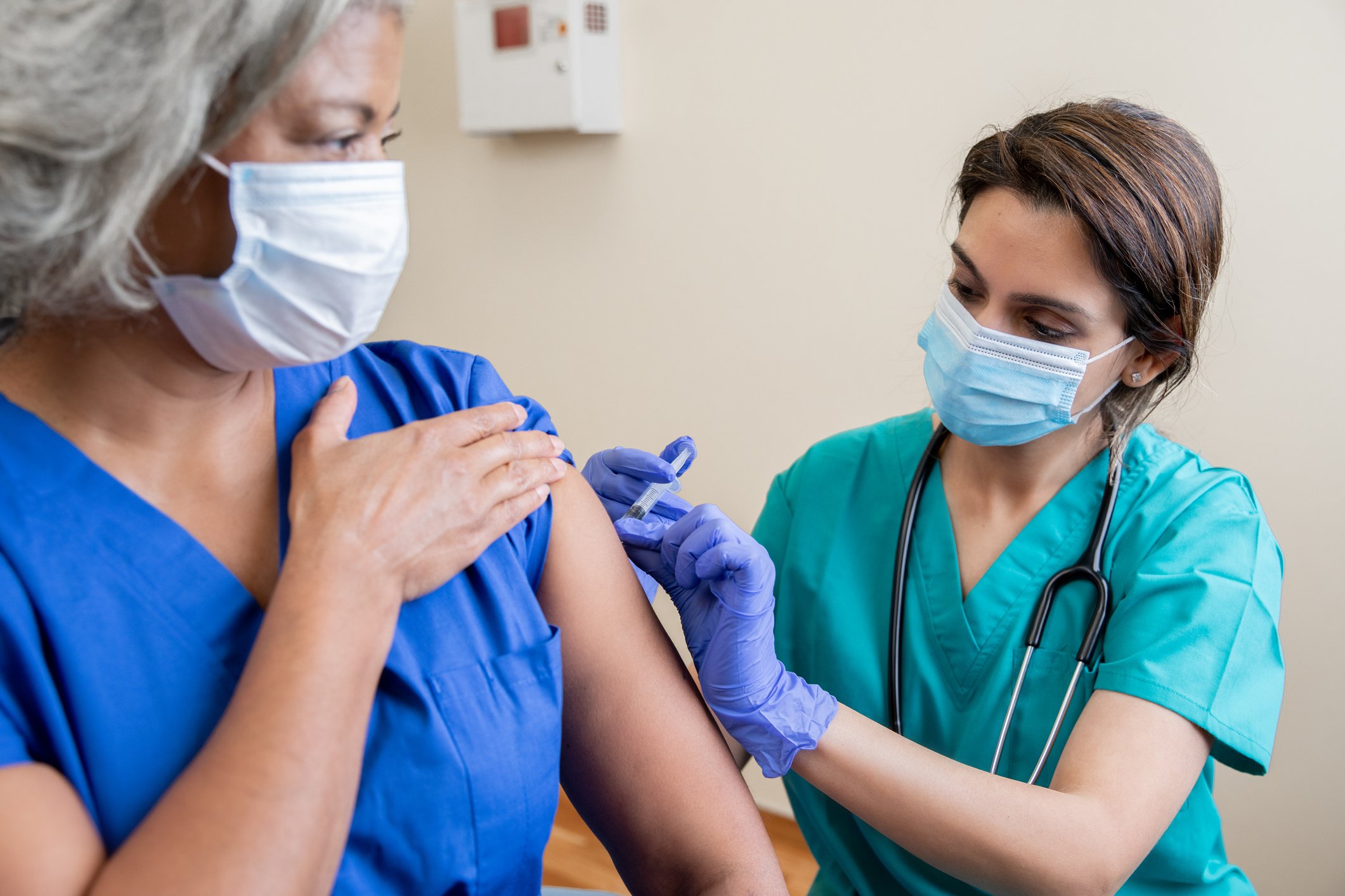 A person receives an injection from a healthcare worker.