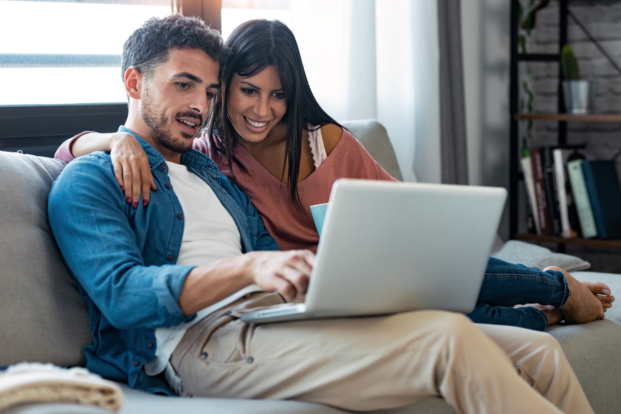 Couple looking at laptop on couch.