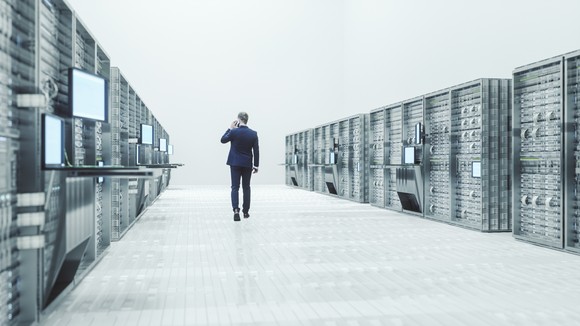 Businessman walks in a massive data center