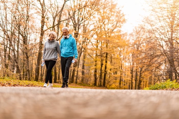 Two older people walking in a park