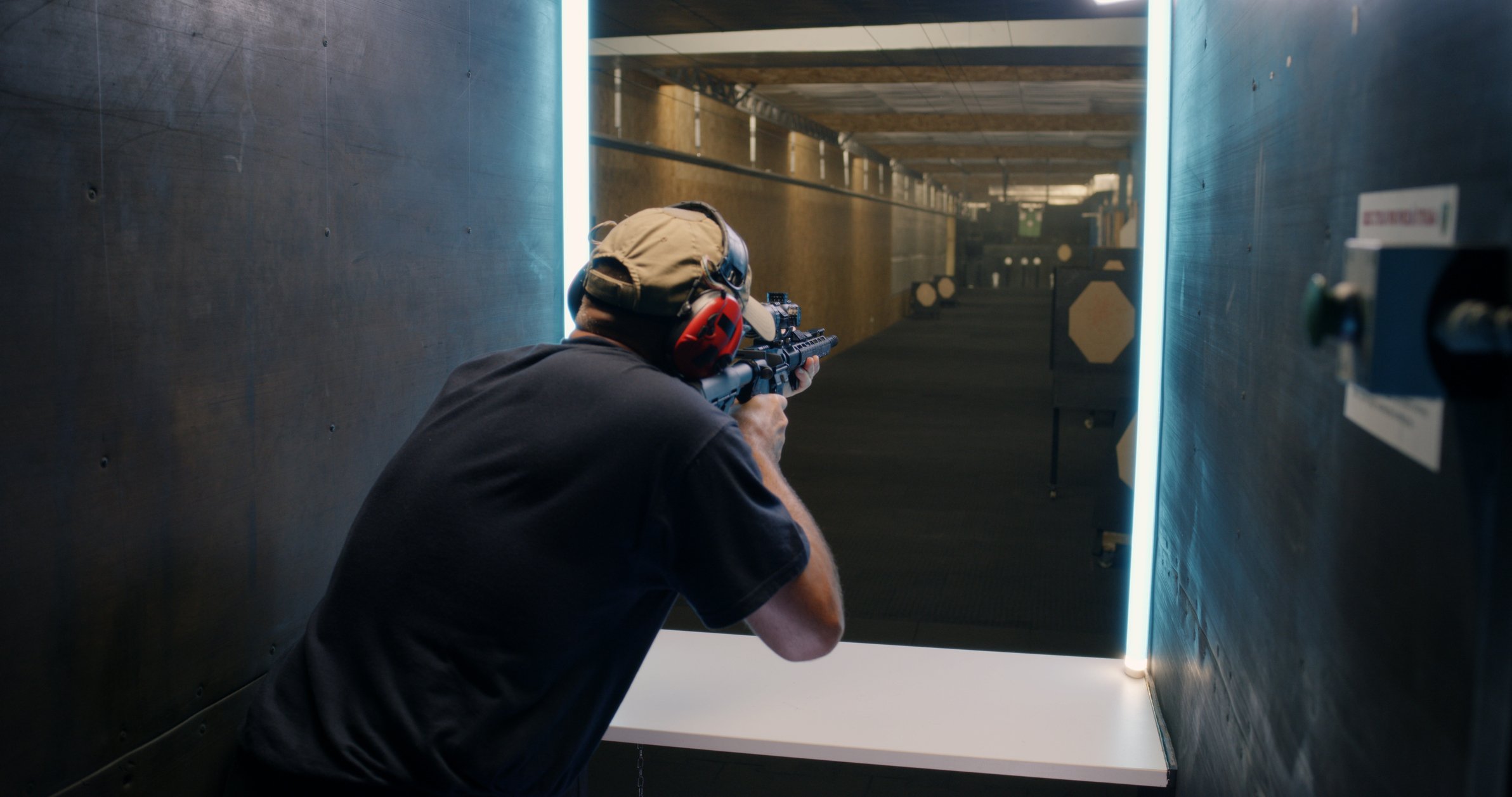 A man aims a rifle at a shooting range.