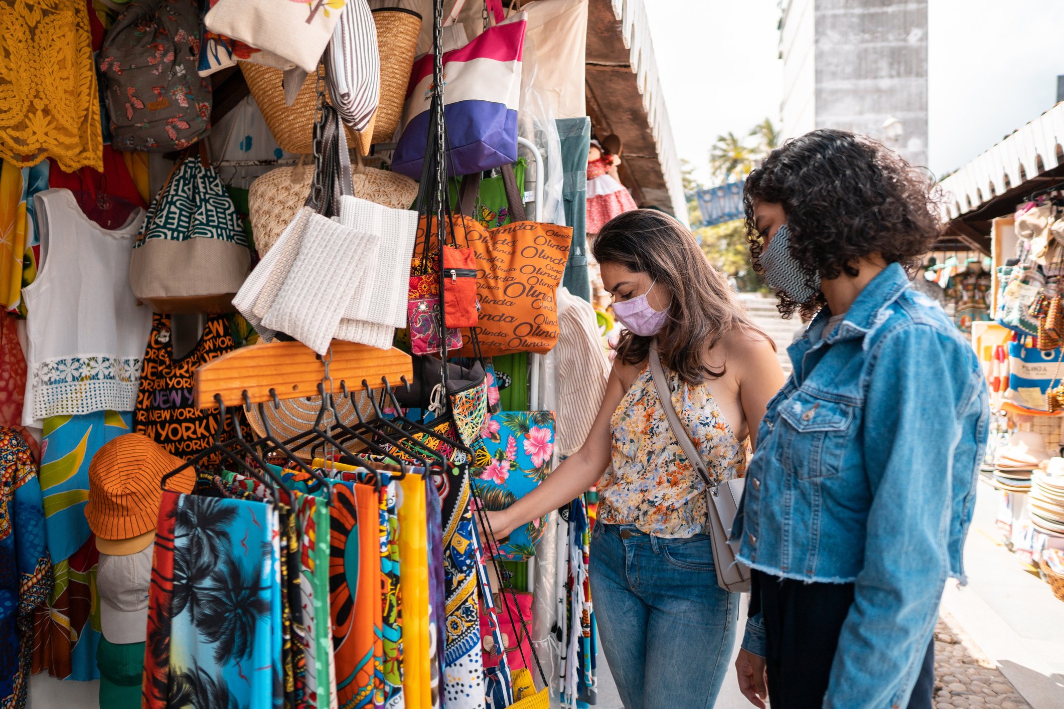 Two people shop in an outdoor Brazilian market.