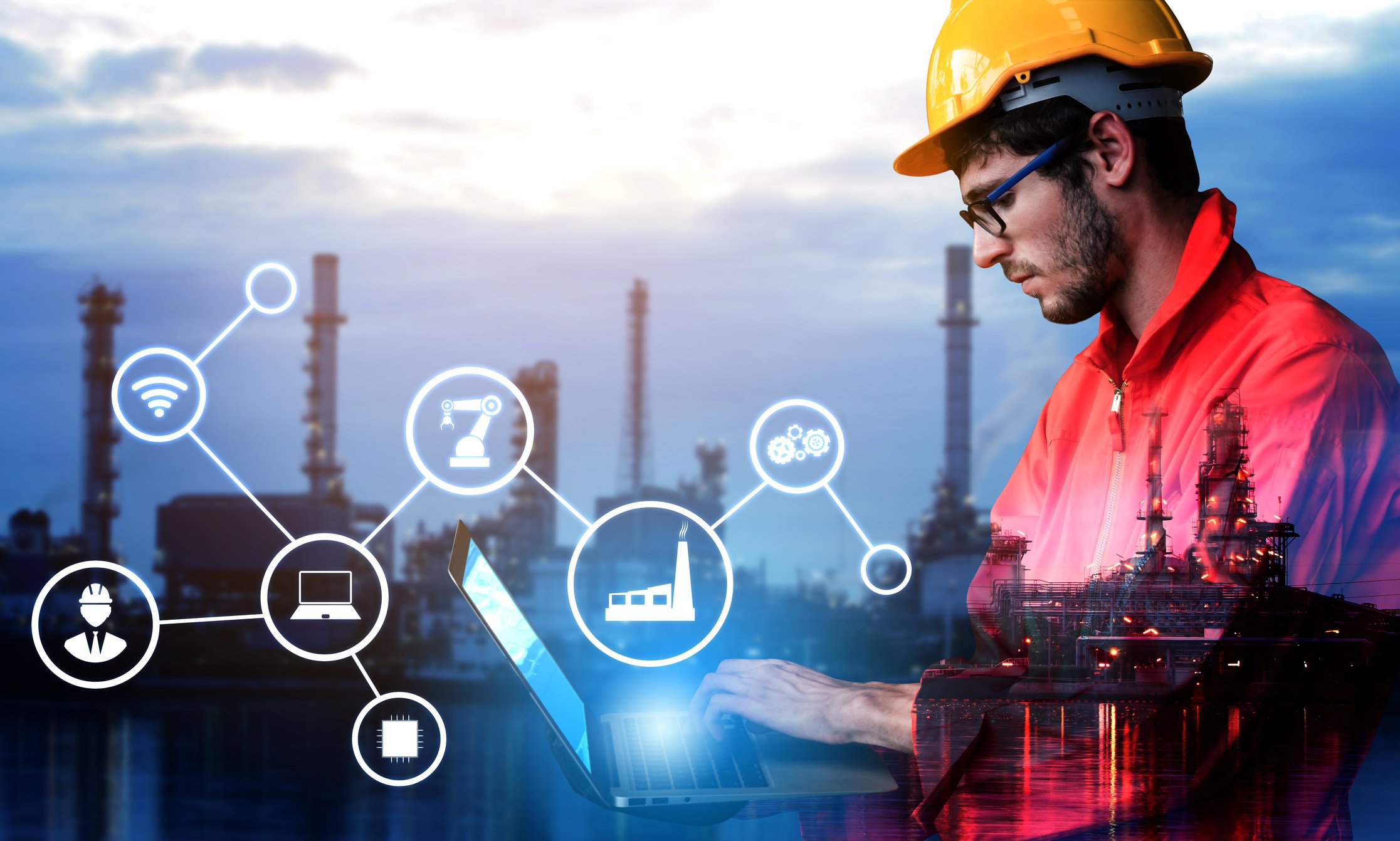 An industrial worker checks a laptop.