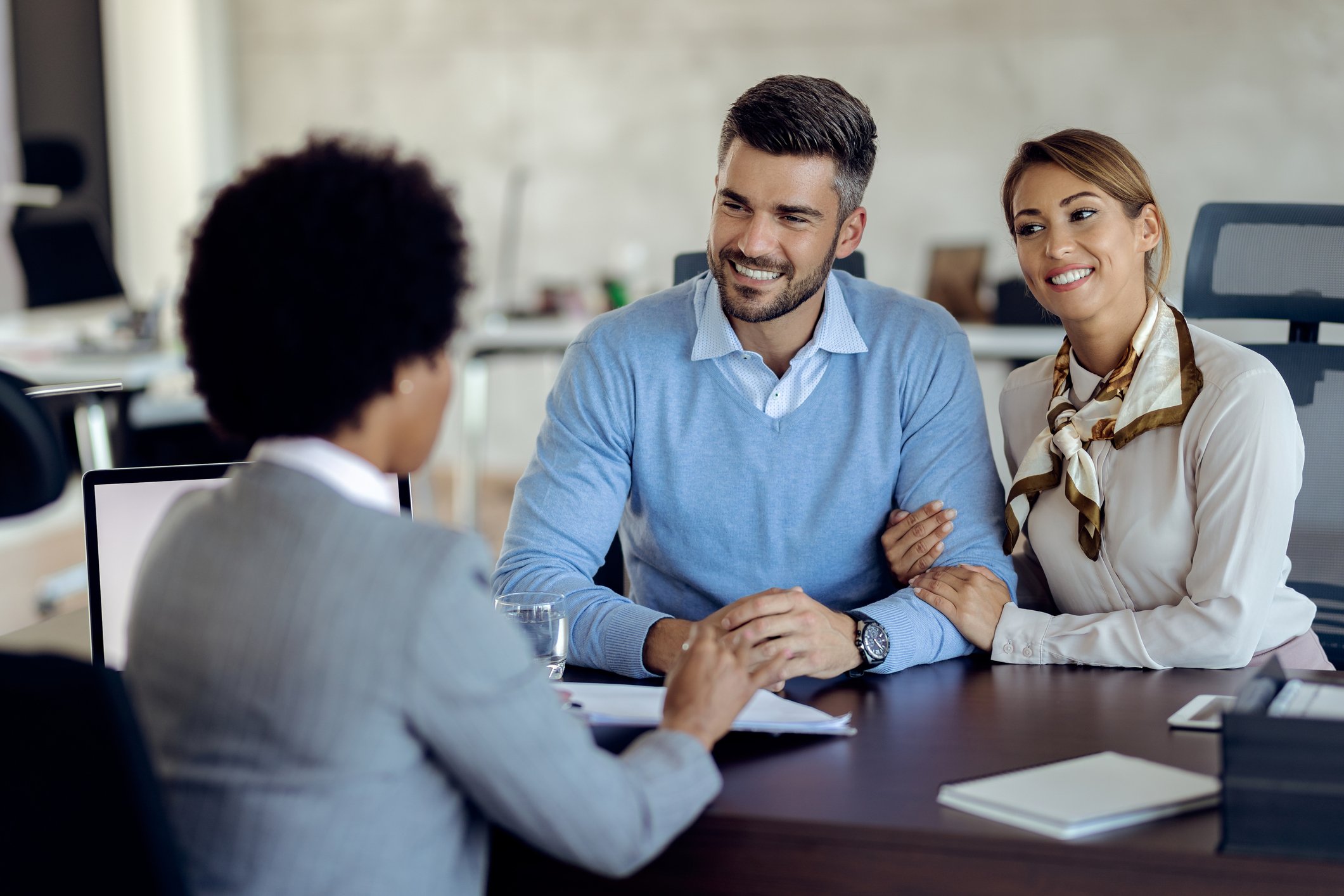 A banker meets with two people in her office.