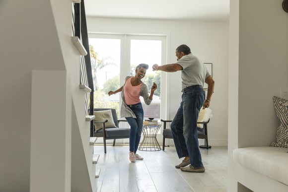 Two people dancing in a living room. 