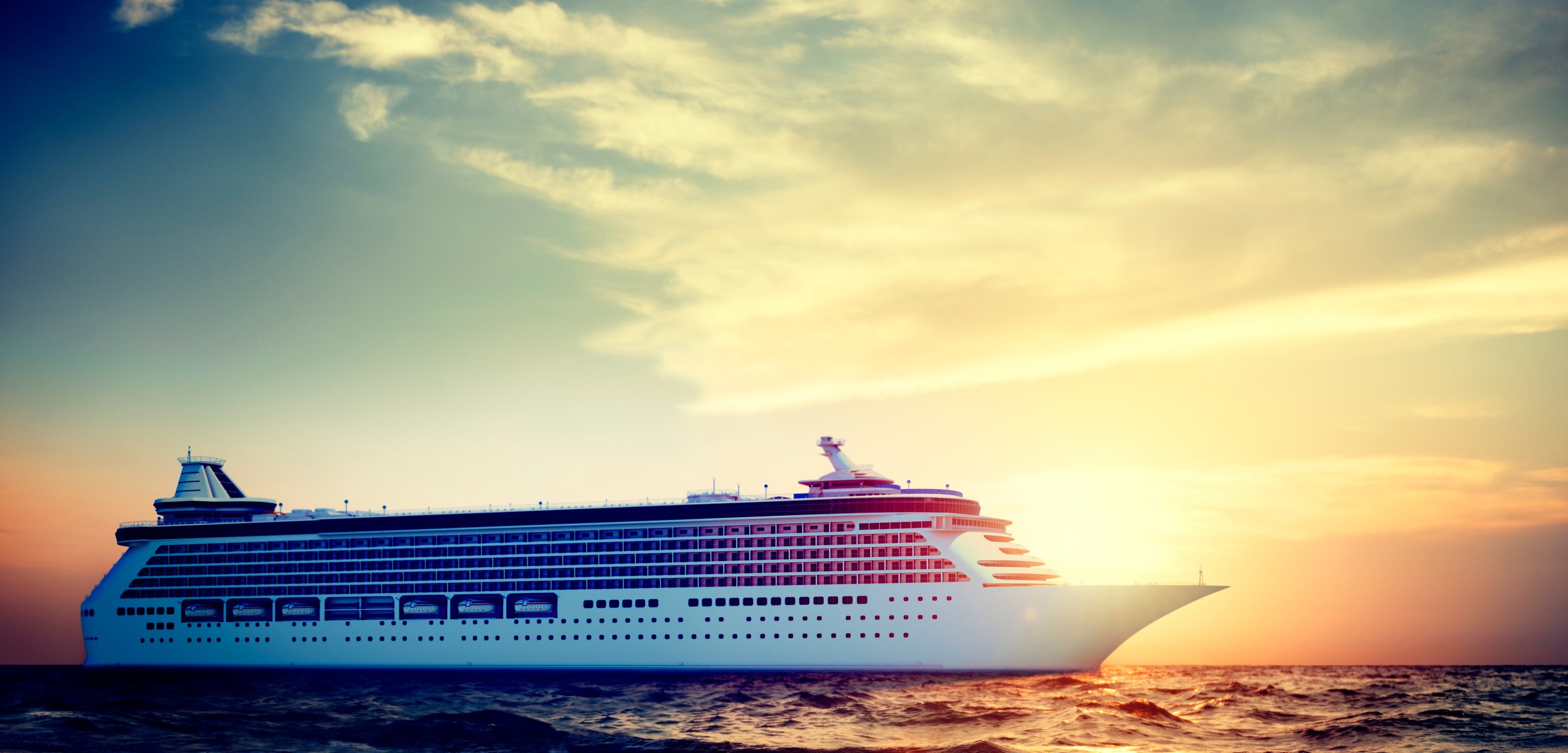 A cruise ship is sailing in the ocean at sunset or sunrise. 