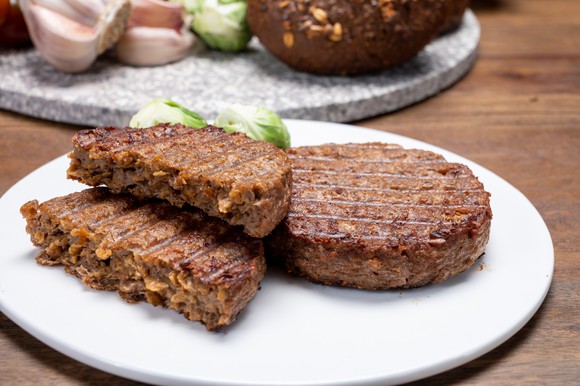 Plant-based meat patties sitting on a plate.