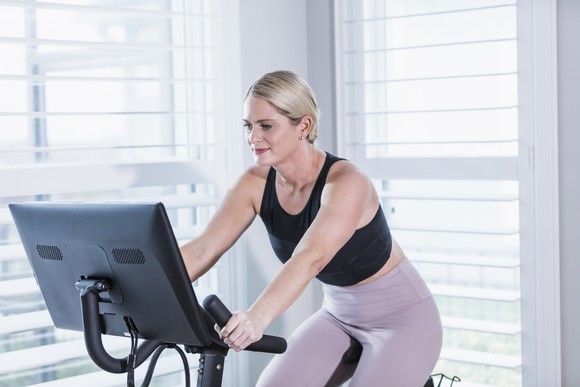 Person riding a stationary exercise bike.