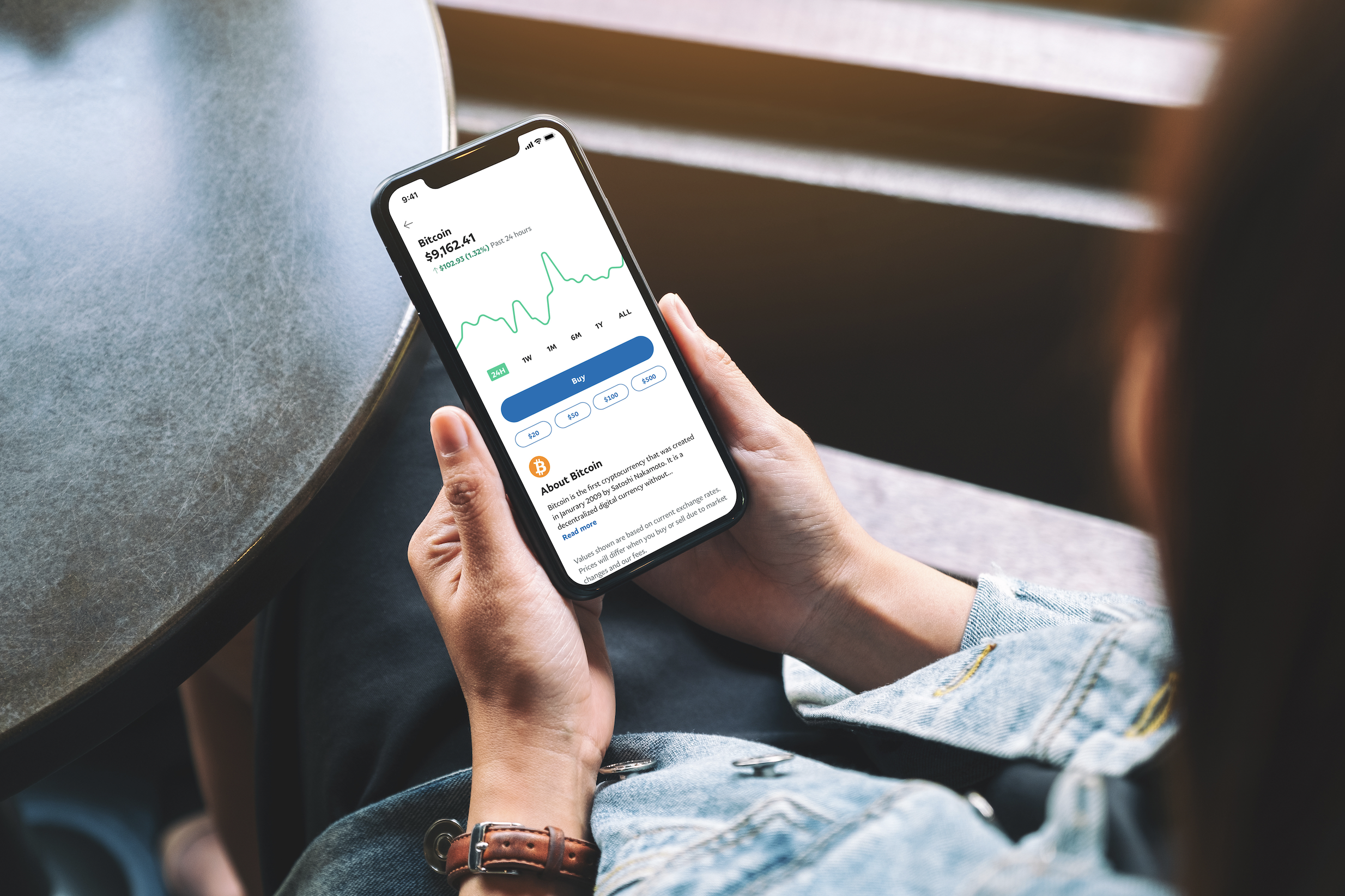 A person holding a phone with the PayPal app open.