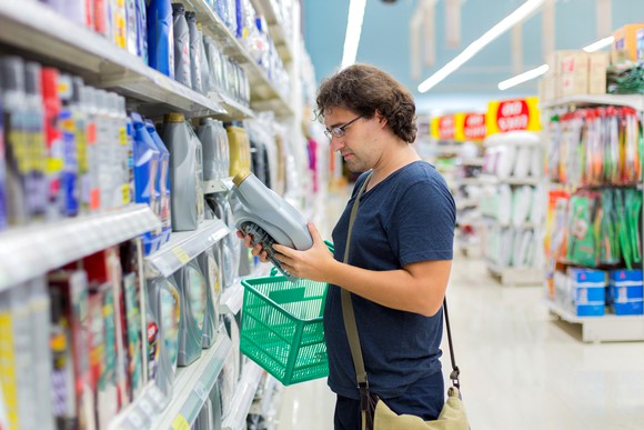 person shopping for motor oil in auto supply store