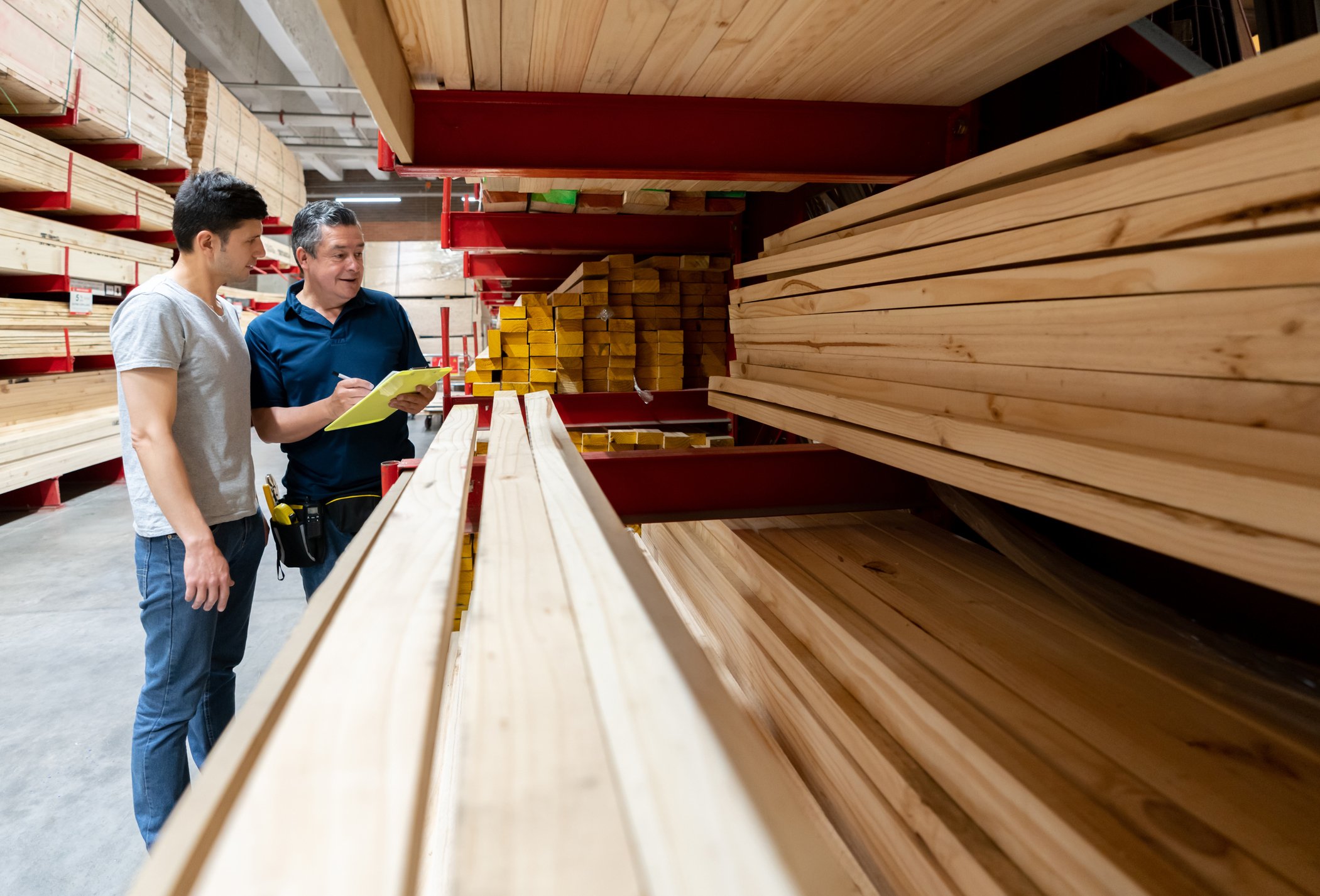 Two people looking at lumber.