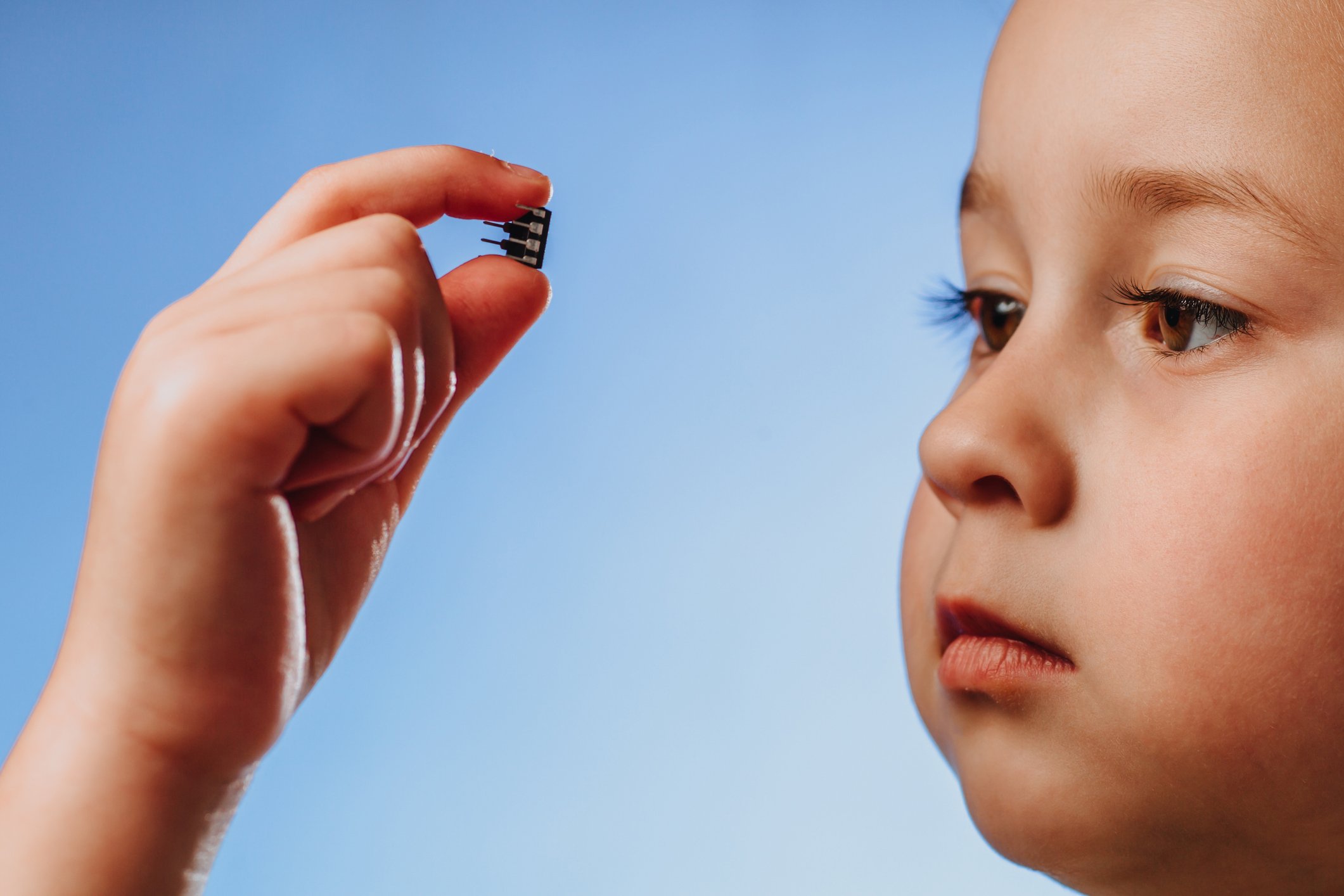 Child examining a semiconductor chip.