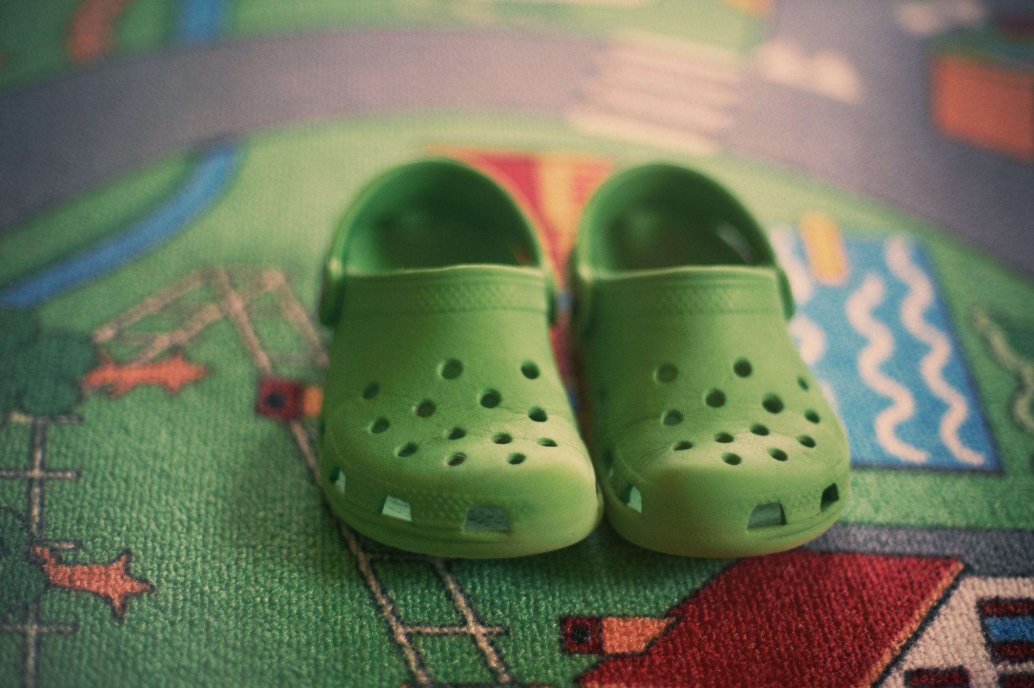 Pair of green foam clog shoes.