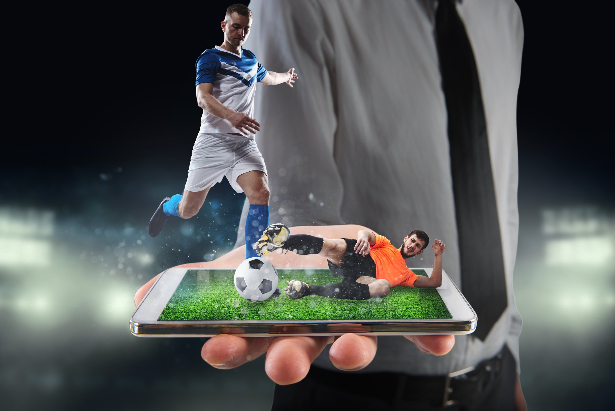 Two soccer players popping out of a smartphone during a game.