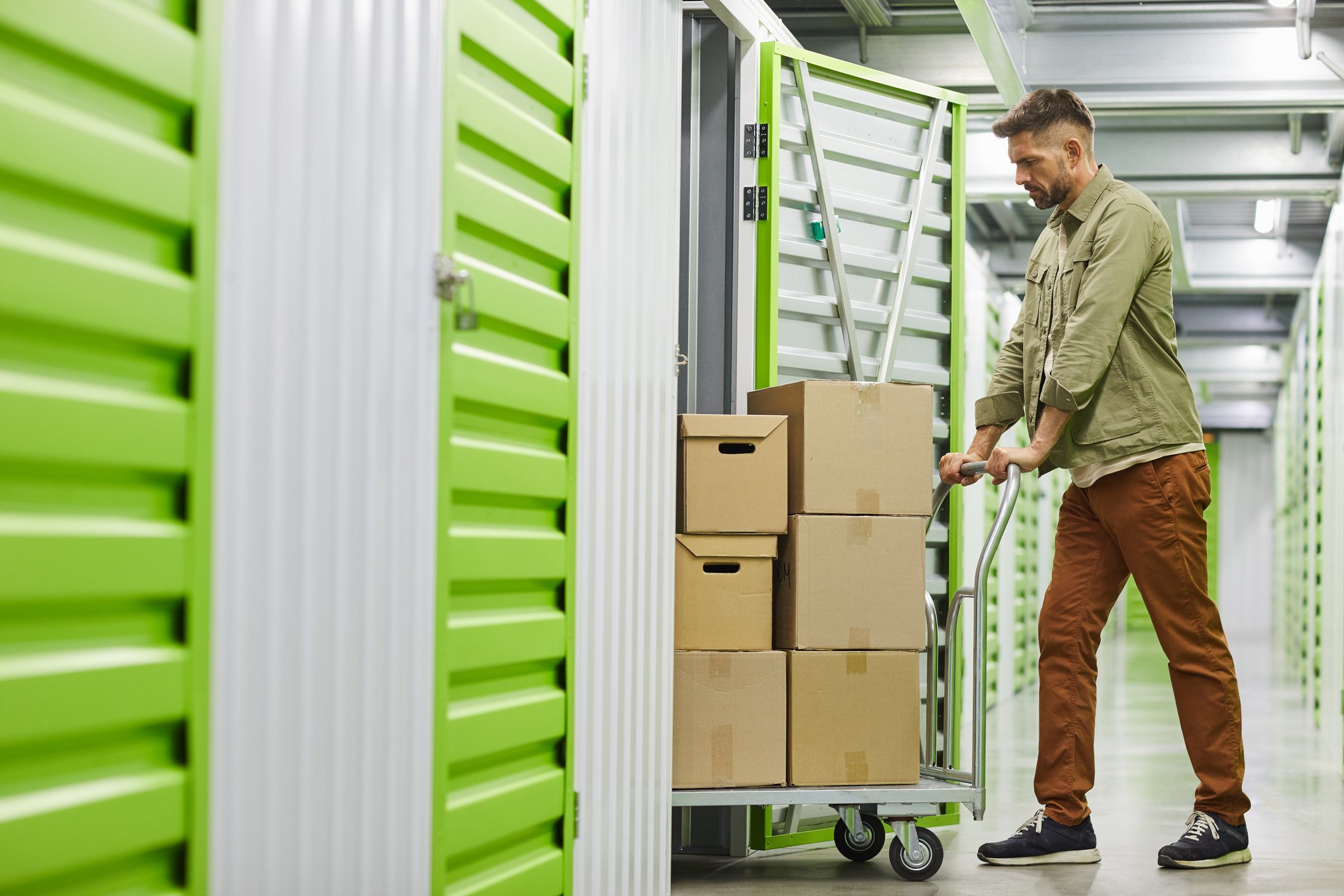 Person loading boxes into self-storage unit.