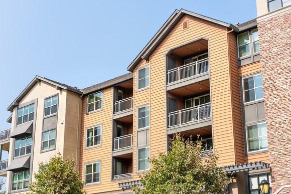 Brown and tan three-story apartment exterior.