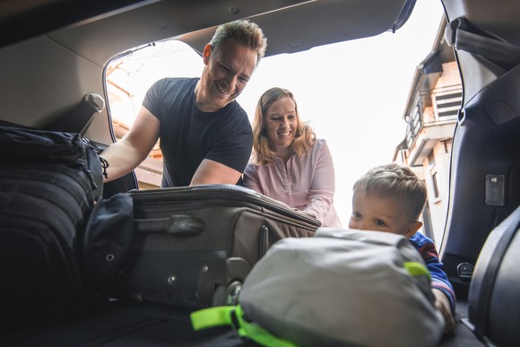 Family loading luggage into a vehicle. 
