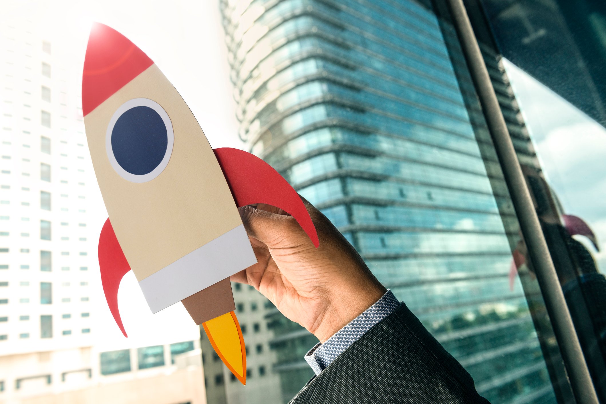 A person holding a paper cutout of a rocket.