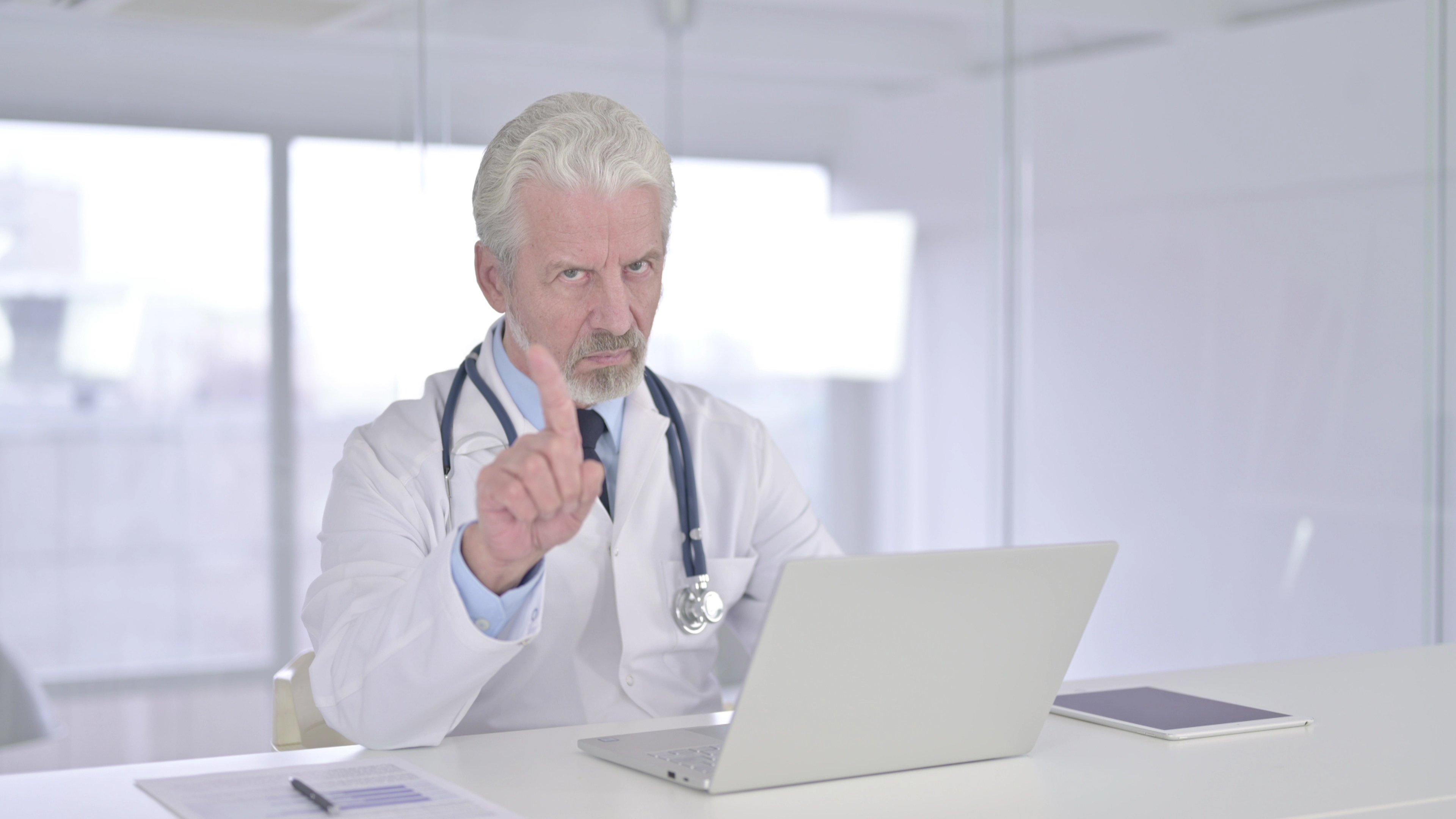 Medical professional wagging a finger.