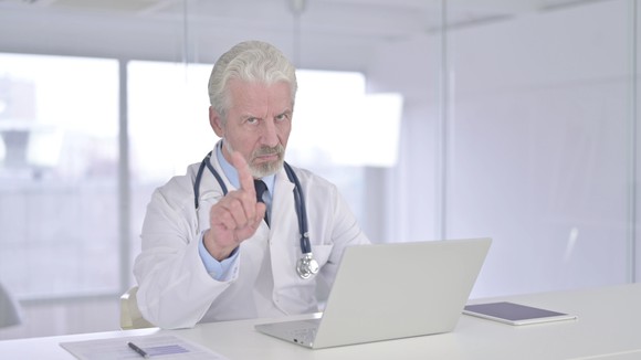 Medical professional wagging a finger.