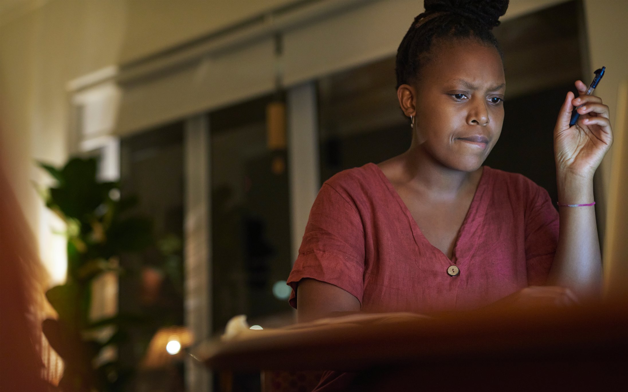 A person looks perplexed while looking at their computer at night. 