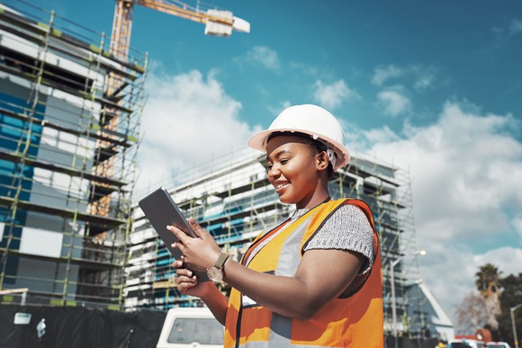 Construction worker using a tablet on a construction site. 