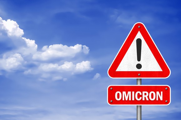 A warning sign displaying "Omicron" with an exclamation mark.