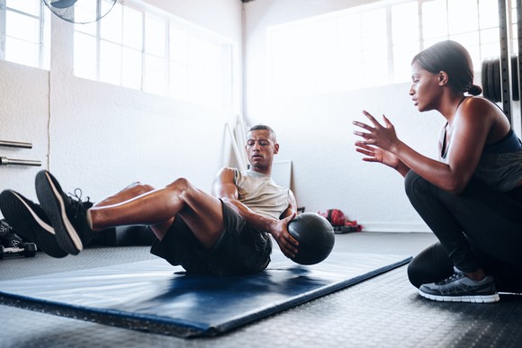 Person working out with a personal trainer.