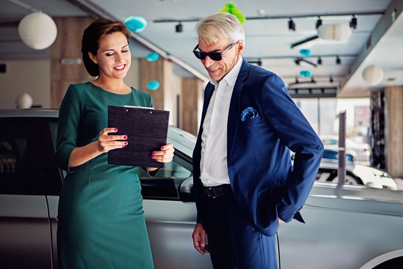 Wealthy person buying a luxury car.