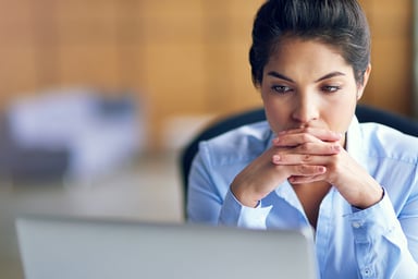 person feeling worried looking at a laptop