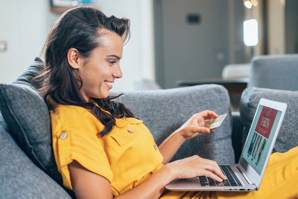 A young woman shopping on a laptop.