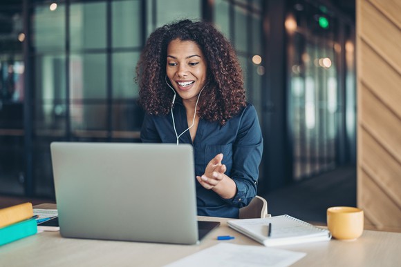 Lady using her laptop to make a video call while working.