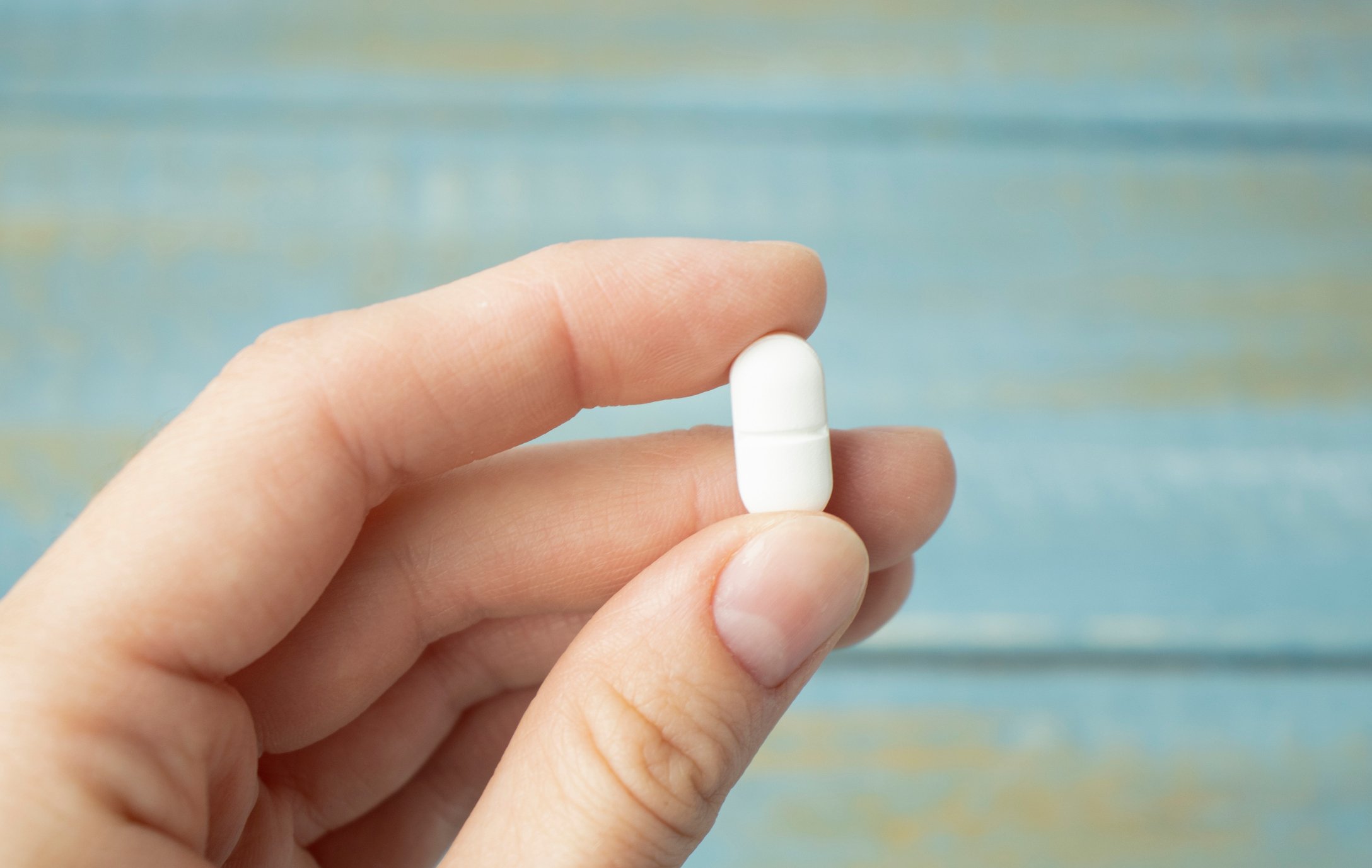 A person is holding a pill. 