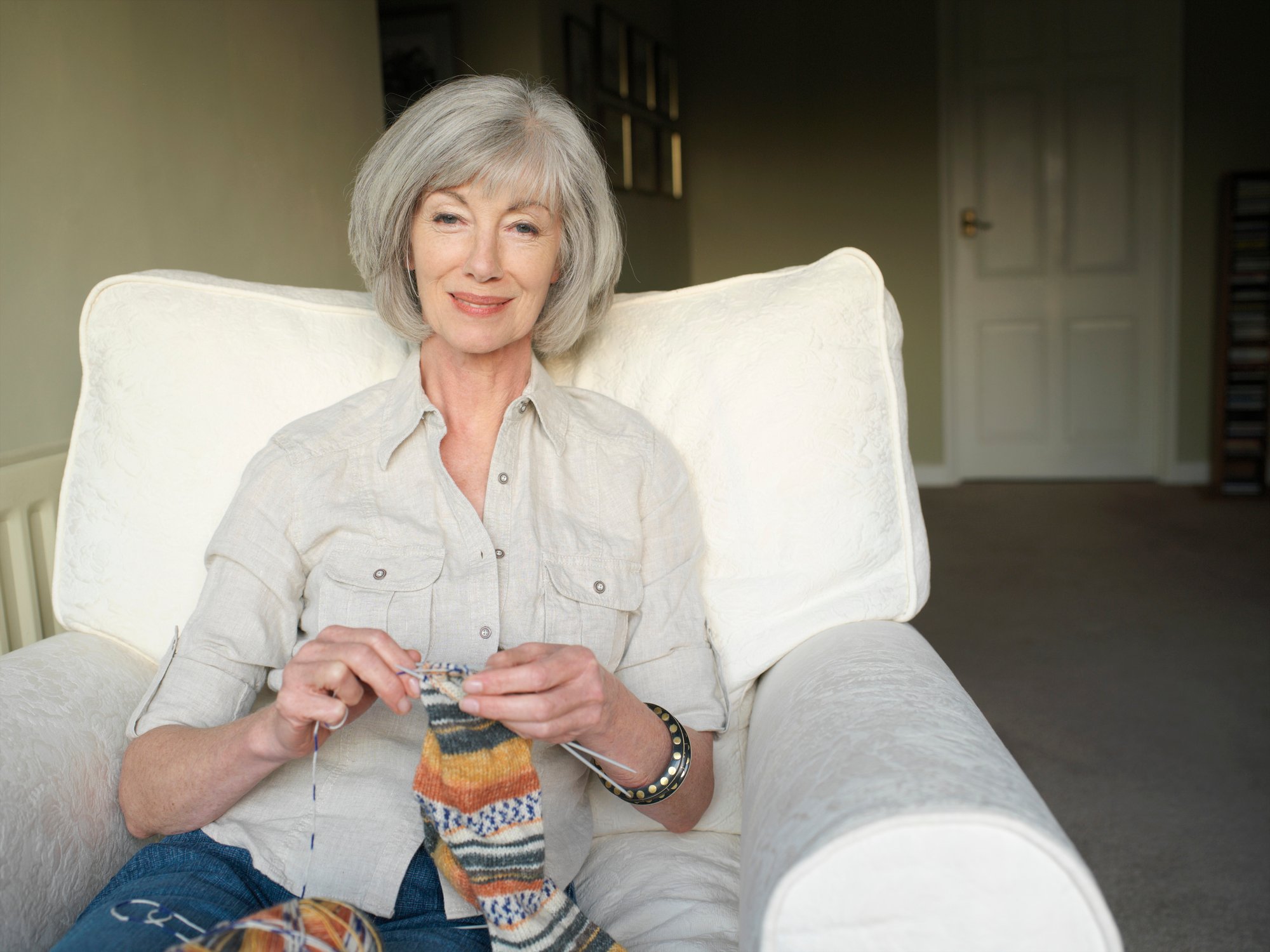 Smiling person knitting.