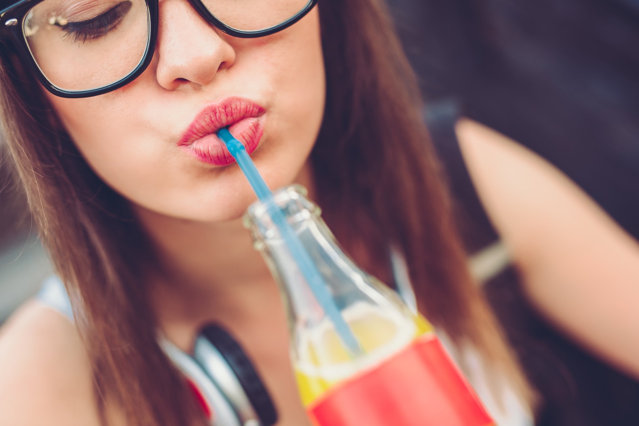 A person drinking a beverage with a straw.
