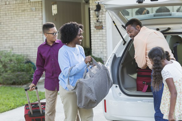 A family loading luggage in their car.