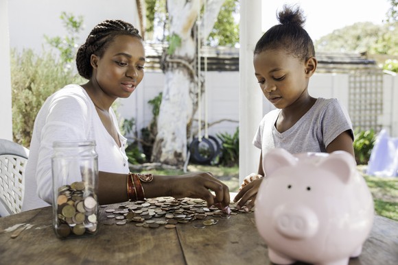 Parent counting coins with child. 