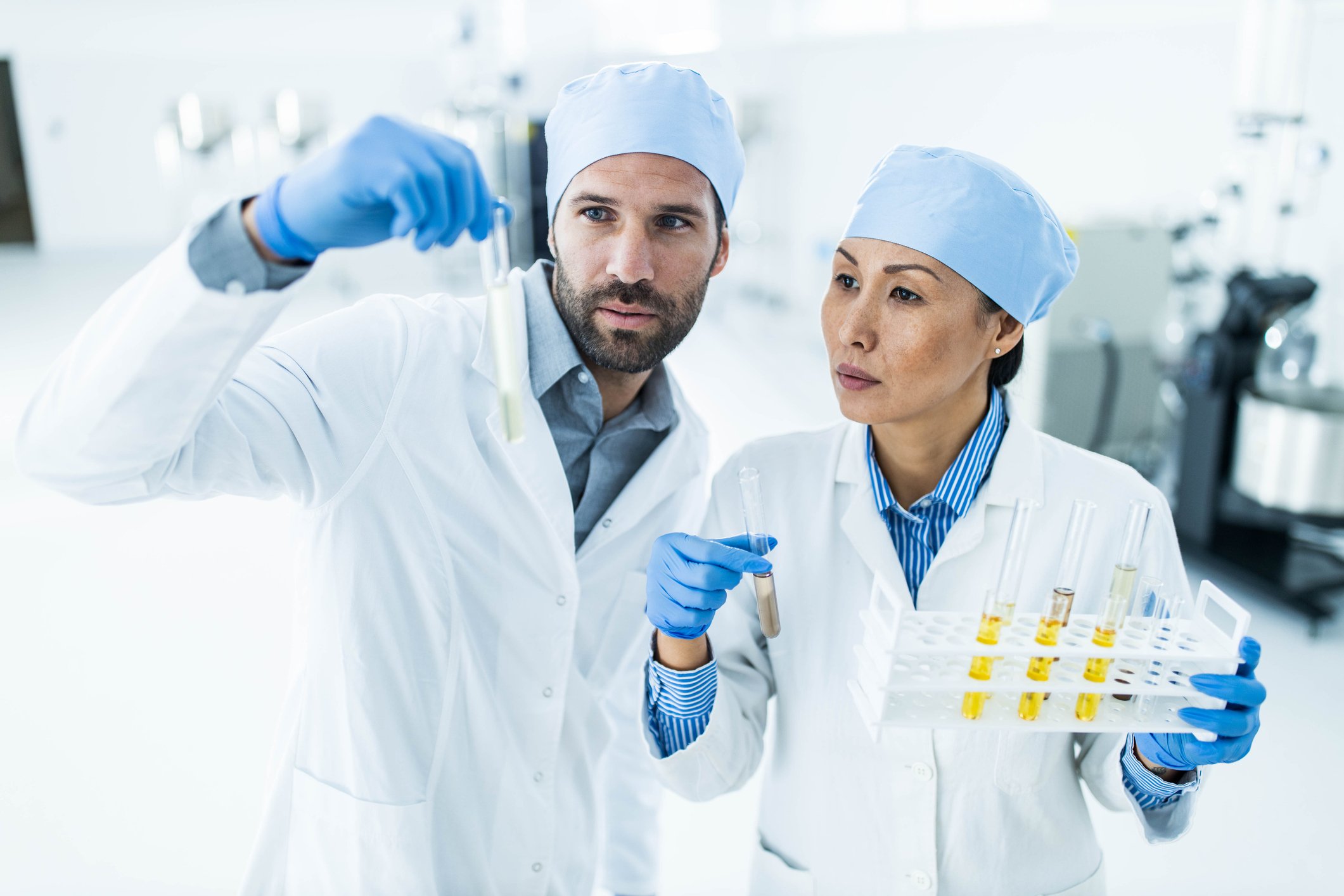 Two scientists reviewing a sample in a tube.