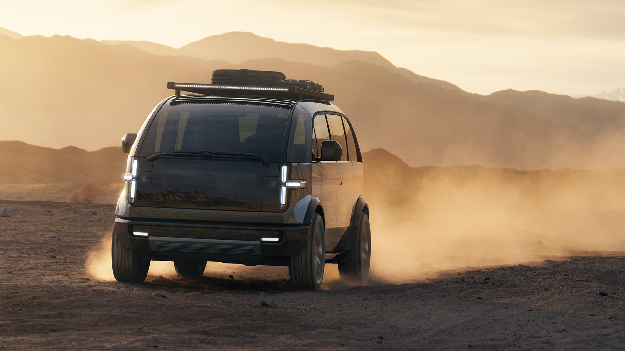 A Canoo electric vehicle driving in the desert.