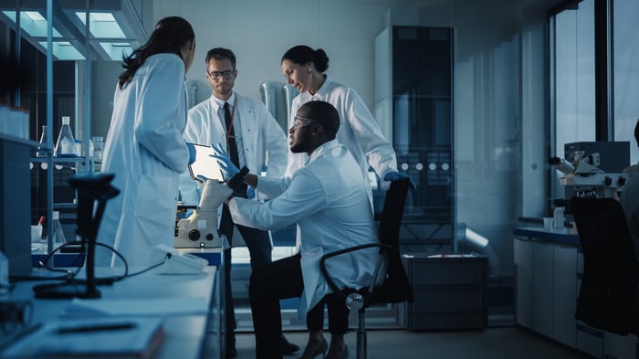 Four people consulting in a lab.