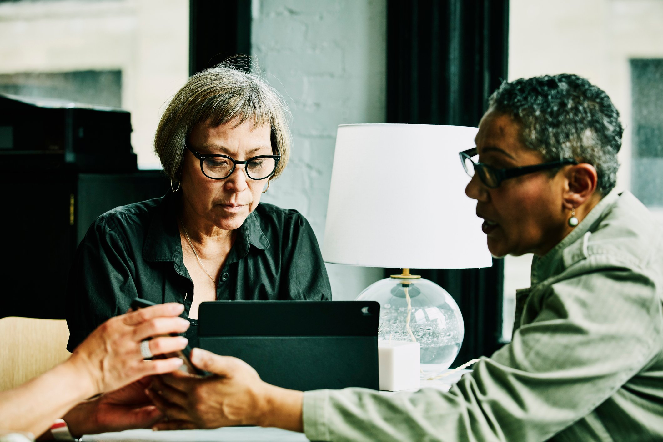 Two people in an office talking and looking at a computer.